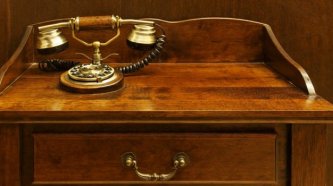 Altmodisches Telefon auf Holzkommode